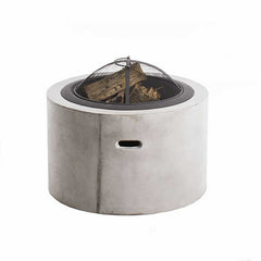 A round fire pit with a concrete frame, steel base, and net cover. Inside, small pieces of wood are placed. The fire pit is set against a plain white background. It's small & compact; making it a perfect addition to any outdoor furniture setup.