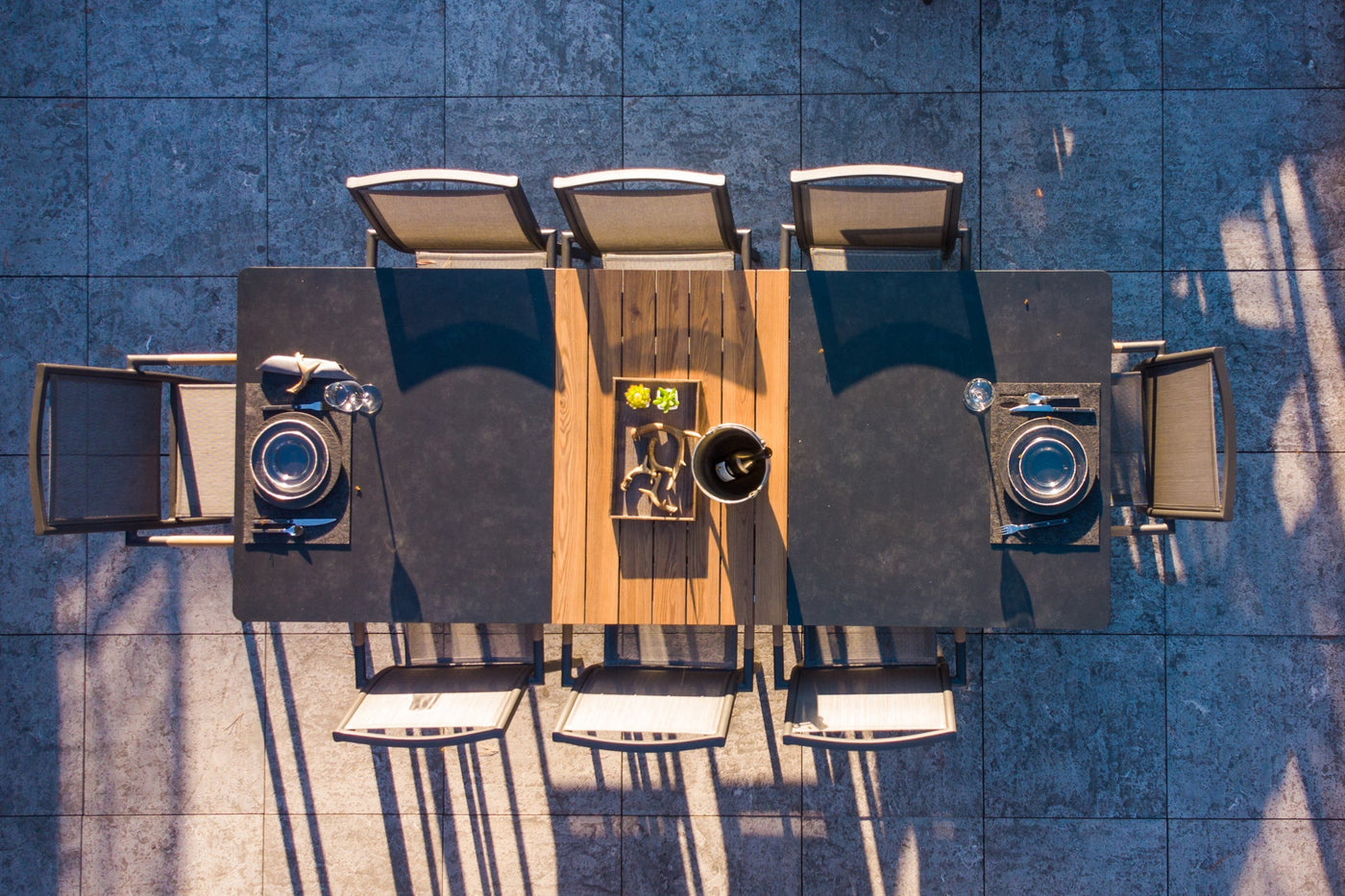 Lisbon Outdoor Ceramic Dining Table featuring a smooth ceramic tabletop and a sleek charcoal metal frame, all displayed against a stark white background.