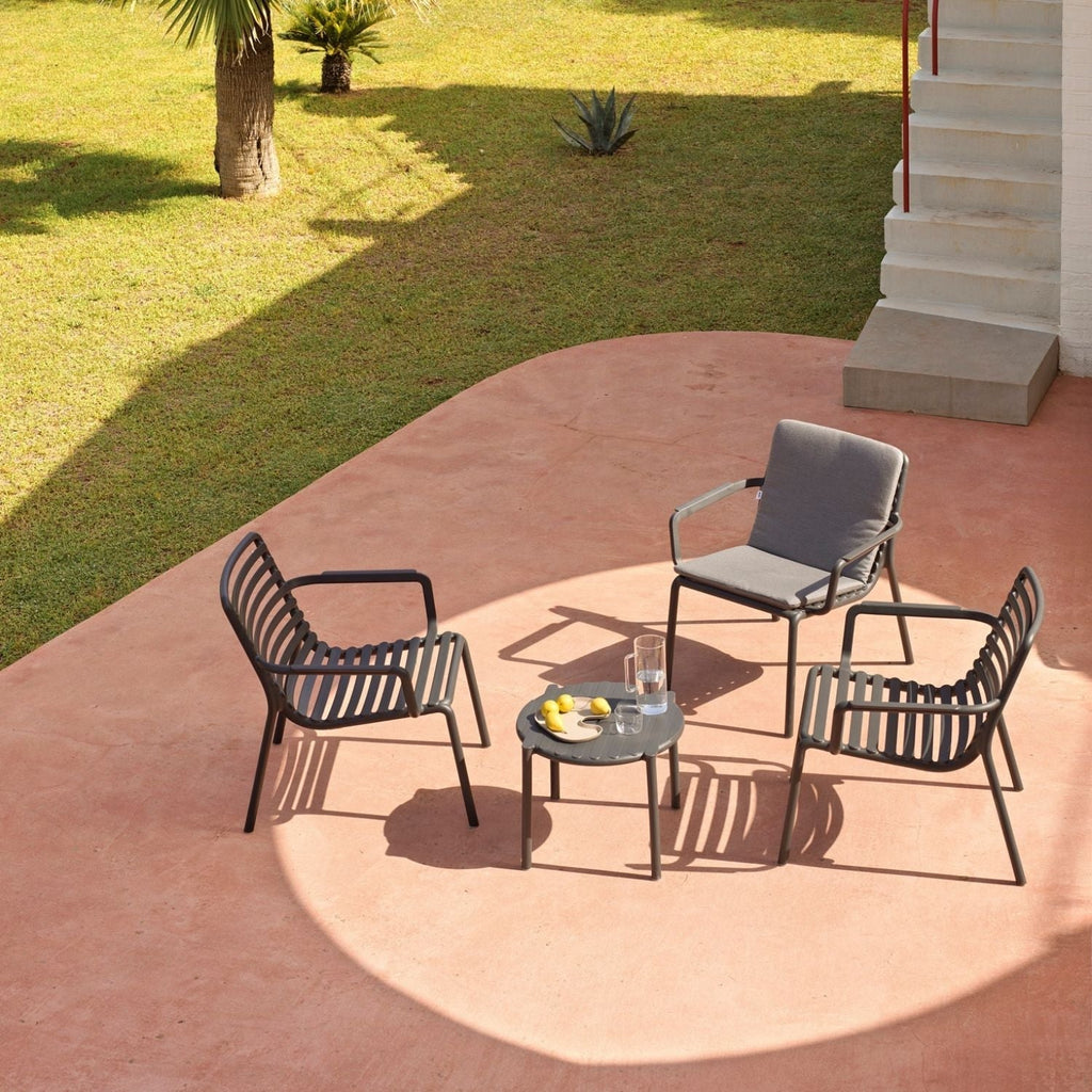 A vibrant outdoor setting featuring some amazing Nardi outdoor furniture pieces. There is a long black extension table and 10 yellow outdoor chairs on a wooden deck, set with food for a welcoming atmosphere.