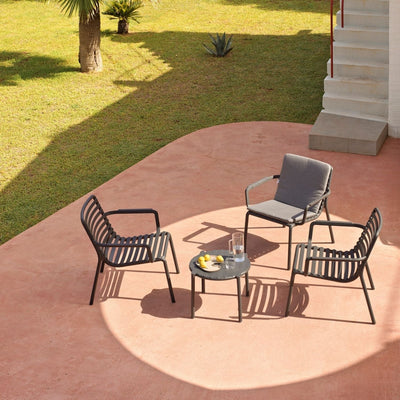 A vibrant outdoor setting featuring some amazing Nardi outdoor furniture pieces. There is a long black extension table and 10 yellow outdoor chairs on a wooden deck, set with food for a welcoming atmosphere.