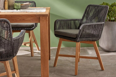 A well-arranged dining table with wooden outdoor chairs, creating a cozy setting for gatherings and shared meals.