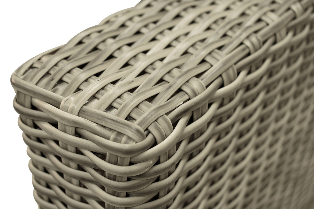 Close-up on the resin wicker armrest of an outdoor lounge set against a plain white background, highlighting the craftsmanship of the wicker outdoor furniture and its organic design.