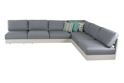 A modern Hannover 6-seater lounge with light grey upholstery and a white base, featuring clean lines, plump cushions, and accessorized with throw pillows in green, teal, and gray tones.