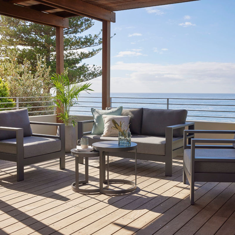 Albury outdoor furniture collection featuring a 3-seater outdoor lounge, armchair, and table, all made from premium Spanish Agora fabric and aluminium, covered with a protective cover on a patio.