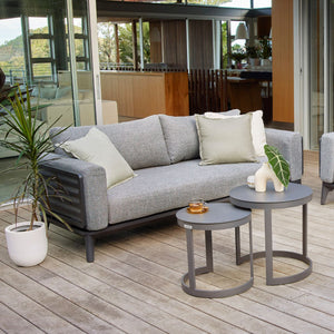 Aluminum outdoor furniture from Alora range, including a comfy outdoor lounge chair and a table on a wooden deck, designed for durability and style.