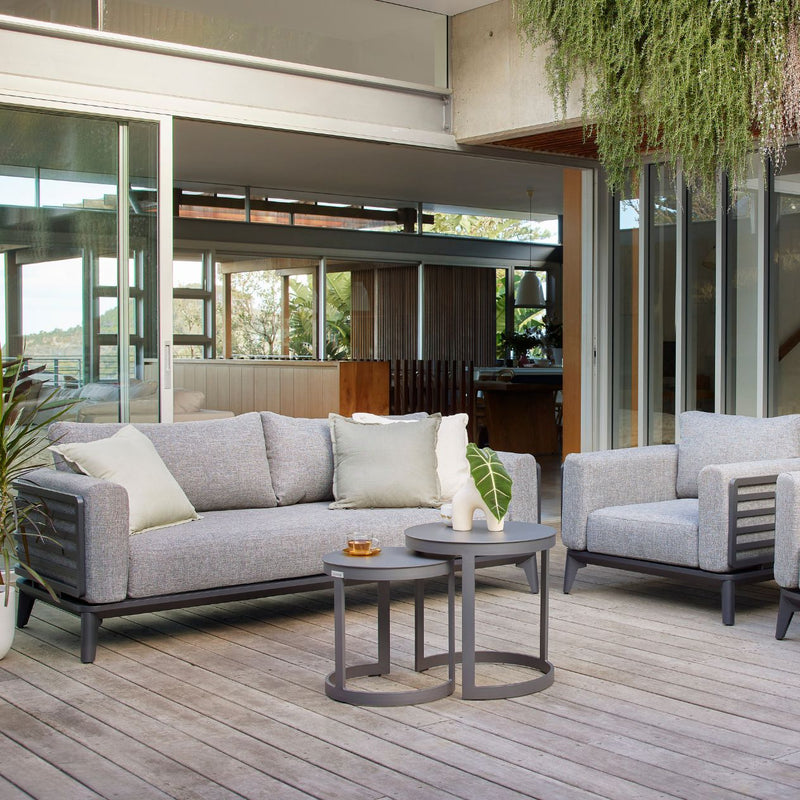 Alora range outdoor furniture set with a 1-seater and 5-seater outdoor lounge, aluminium outdoor furniture including a table and chair, on a patio with a potted plant.