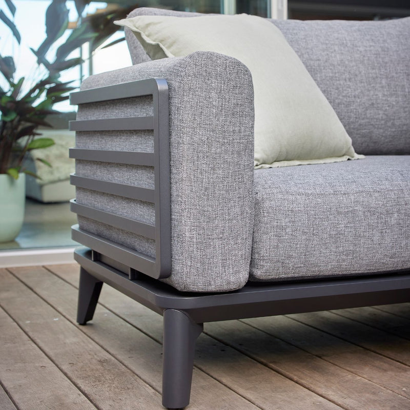 Alora range aluminium outdoor furniture, featuring a 1 to 5-seater outdoor lounge with cushions, durable for Aussie sun, on a wooden deck with a pillow.