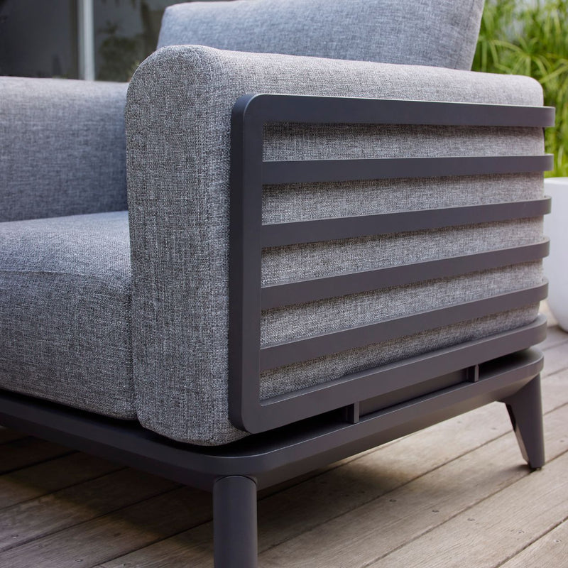 Aluminium outdoor furniture from Alora range, featuring a grey outdoor lounge couch on a wooden floor, designed for durability and comfort.