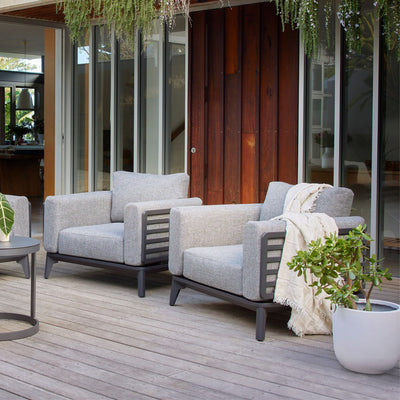 Aluminum outdoor furniture from Alora range, including a comfy outdoor lounge chair, 5-seater spreader on a patio with a couch, chairs, and a potted plant.