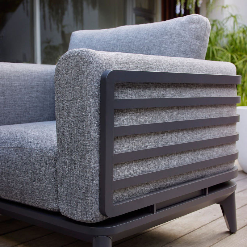 Aluminum outdoor furniture from Alora range, including a gray outdoor lounge chair on a wooden floor, designed for durability and comfort.