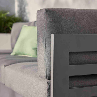 Charcoal and white Como sofa, a versatile piece of aluminum outdoor furniture, perfect as outdoor balcony furniture. Features a grey couch with a green pillow.