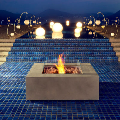 Ecosmart Base 40 square grey firepit placed in an outdoor area by the pool, enhancing the outdoor furniture setting