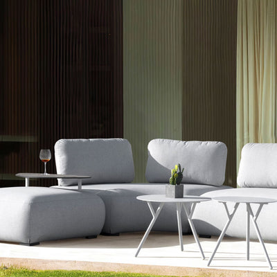 Corner of a light grey Iowa outdoor upholstered lounge with a matching coffee table, set in the outdoor area of a modern house, with sunshine beaming on it, creating a warm and inviting outdoor living space.