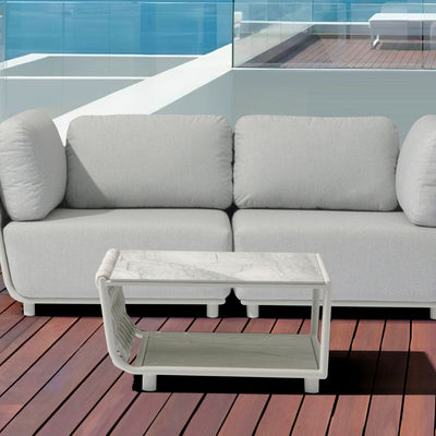 Outdoor furniture from the Lawson Collection, including a white couch, outdoor coffee table, and other pieces, on a wooden floor.