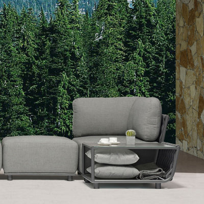 Lawson Outdoor Rope corner lounge with matching attached coffee table, featuring a shelf that stores two pillows. The table surface holds a tea set and a succulent plant, all set in a serene outdoor living space with trees in the background, creating a peaceful and stylish alfresco atmosphere.