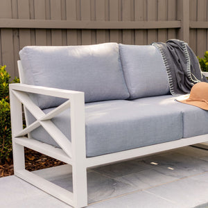 Blue and white aluminum outdoor furniture from Linear Lounge collection, including outdoor chairs and a couch, perfect for an outdoor lounge on a patio.