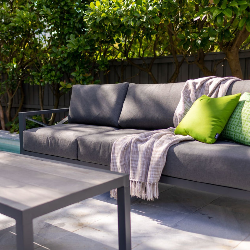 Aluminum outdoor furniture from Linear Lounge collection, including outdoor chairs and a couch in a backyard setting, perfect for outdoor lounge.