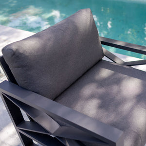 Aluminum outdoor furniture from Linear Lounge collection, including outdoor chairs and outdoor lounge, in charcoal or white, next to a swimming pool.
