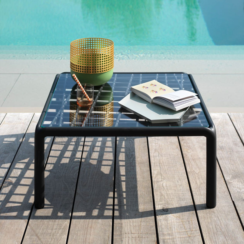 Modern Nardi Komodo Tavolino Vetro outdoor furniture, a concrete table with a clear glass top and durable resin frame.