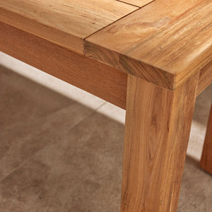Close-up on the corner of a brown, rectangular Polly wooden outdoor table, perfect for alfresco furniture setups.