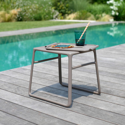 Champagne-hued Pop side table, a piece of outdoor furniture with a weather-resistant resin frame, ideal as a concrete table.