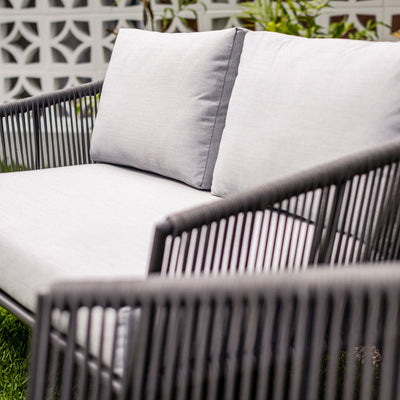 Outdoor furniture from Truro Rope Series, including an outdoor lounge chair and rope chair, on a lush green field.