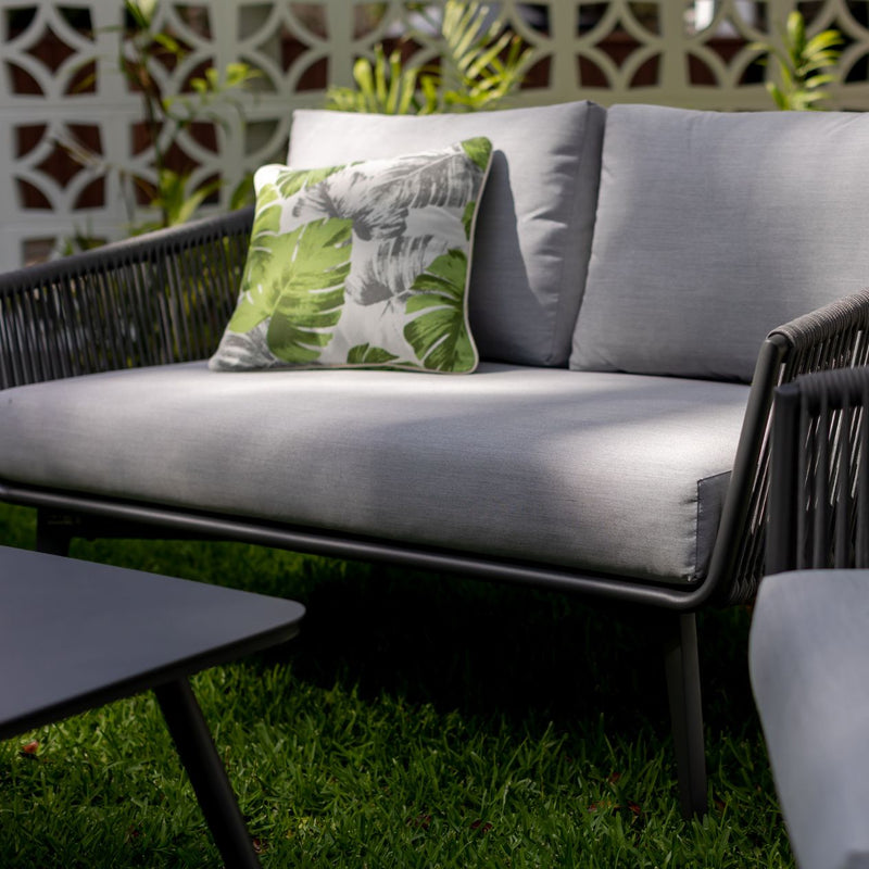 Outdoor furniture set from Truro Rope Series, featuring a rope chair, outdoor lounge chair, 2-seater and 3-seater sofas, and a footrest near a table in a yard.