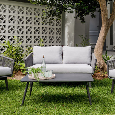 Outdoor furniture set from Truro Rope Series, featuring a white outdoor lounge chair, rope chair, and sofa in a yard.