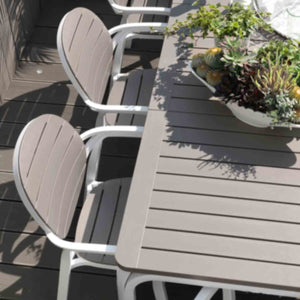 Light brown Nardi Tevere outdoor extension dining table with cutlery and fruit, accompanied by 4 aqua chairs, styled for a chic alfresco furniture experience.