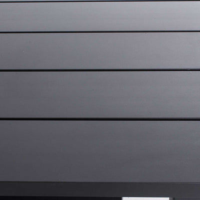 Close-up on the black aluminium surface of a modern rectangular outdoor dining table.