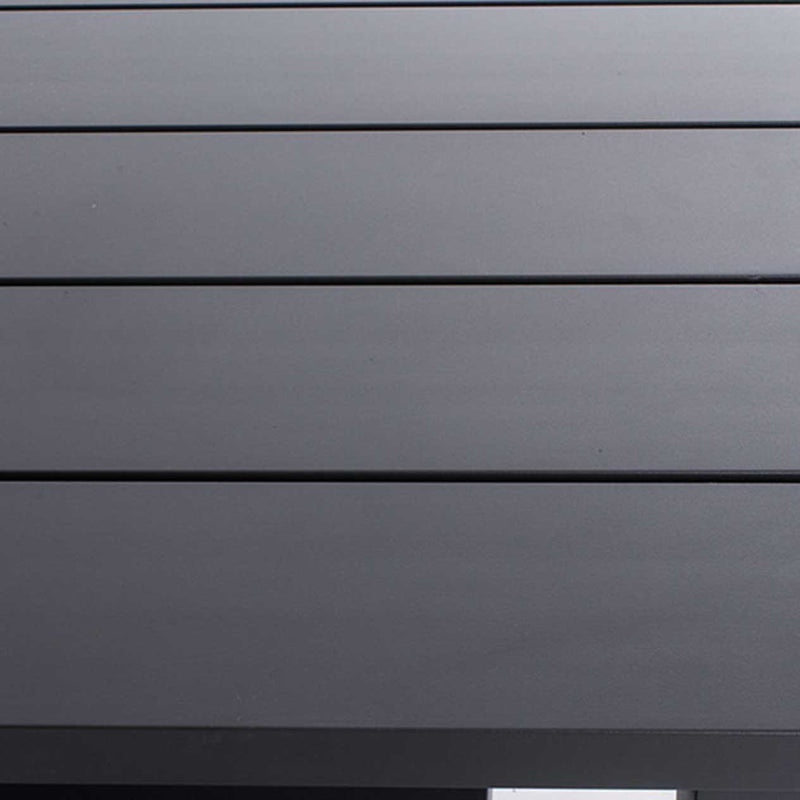 Close-up on the black aluminium surface of a modern rectangular outdoor dining table.
