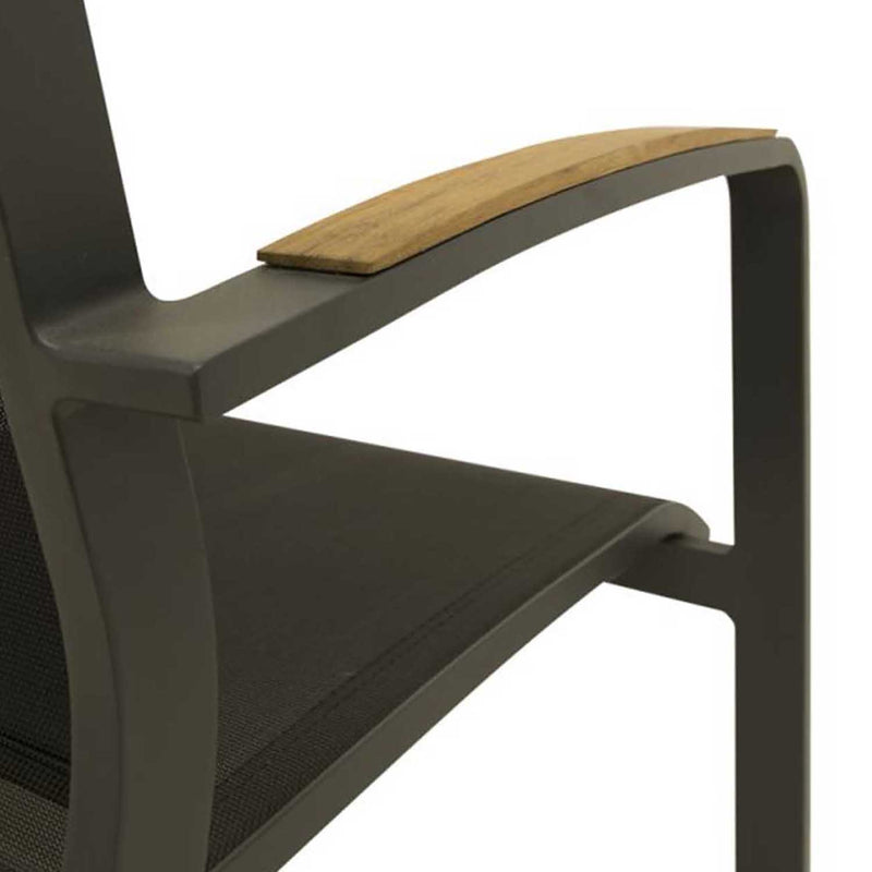 A close-up shot of an aluminium dining chair with teak arm, charcoal frame, and charcoal Textilene. Outdoor furniture, outdoor chairs, aluminium outdoor furniture.