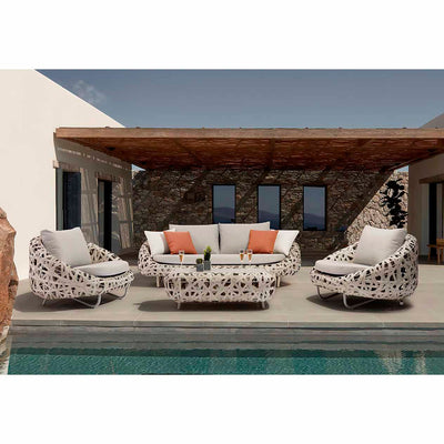 Poolside setup featuring two wicker lounges, a two-seater lounge, and a matching coffee table, all in a modern European outdoor space, perfect for alfresco furniture style.