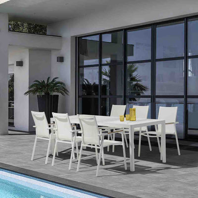 White Ella Outdoor Aluminium Dining Table with Ceramic Glass Top surrounded by six matching aluminium patio chairs, set poolside during a hot summer day. The table is decorated with yellow glasses of water, adding a vibrant touch to the alfresco dining experience.
