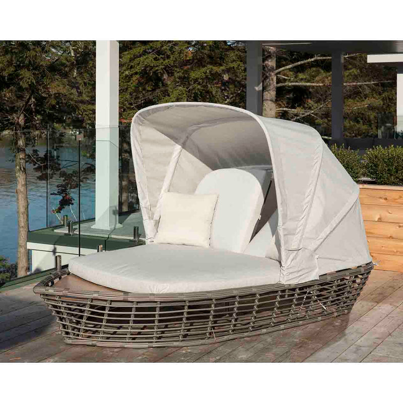 Beige Ocean Grove Outdoor Wicker Daybed with Canopy set on a wooden deck, perfect for summer relaxation and enhancing outdoor living.