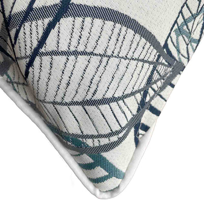 Close-up on the corner of a blue, grey, and white outdoor scatter cushion with a lakeside-inspired leaf pattern design, perfect for outdoor furniture setups.