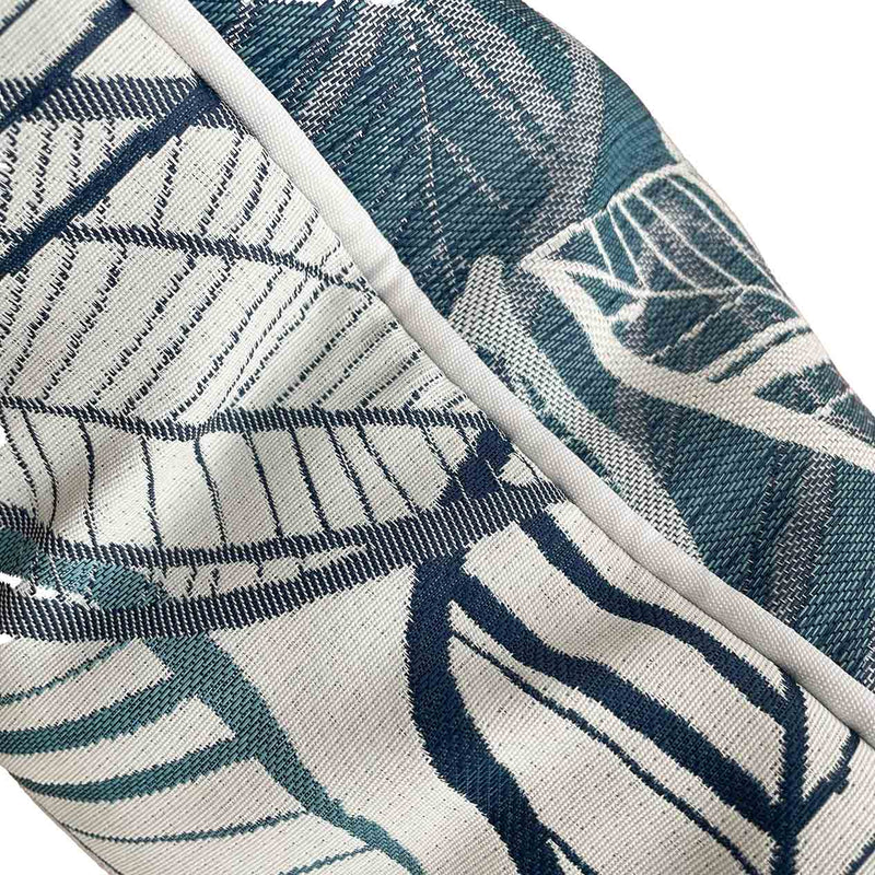 Close-up on the side of a blue, grey, and white outdoor scatter cushion with a lakeside-inspired leaf pattern design, perfect for outdoor furniture setups.