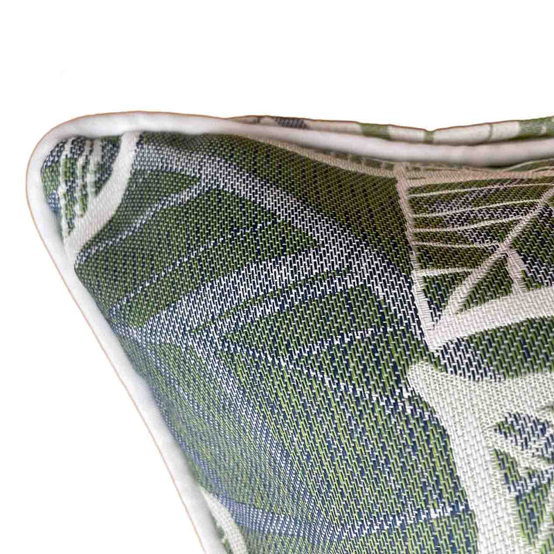 Close up on the corner of an outdoor scatter cushion with a white, grey, and green Amazon-inspired leaf pattern design, perfect for outdoor furniture setups.