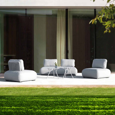 Light-grey 4-seater Iowa outdoor upholstered modular lounge with 2 matching coffee tables, set in the outdoor area of a modern house, with sunshine beaming on it, creating a warm and inviting outdoor living space.