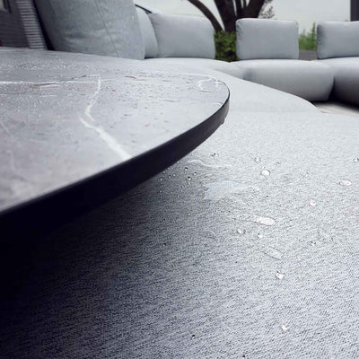A close-up of an aluminum upholstered ottoman with grey frame and grey fabric set against a white background. Outdoor furniture, outdoor balcony furniture, outdoor lounge chair.