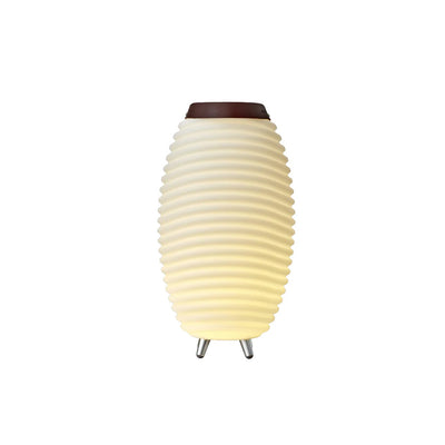 The Kooduu Synergy Bluetooth Speaker LED Lamp, turned on, emits a warm soft yellow light, set against a plain white background. The brown leather handle is completely down.
