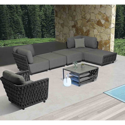 Six-seater rope modular lounge with matching coffee table, set in a sunny outdoor area with lush greenery in the background, ideal for outdoor living.