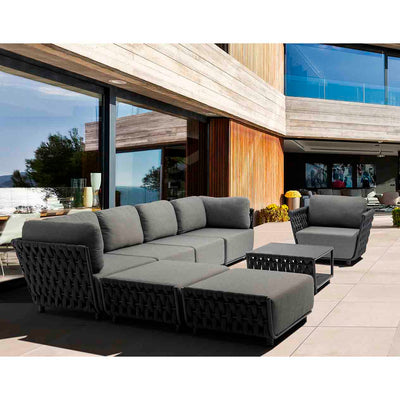 Seven-seater outdoor rope modular lounge with a matching coffee table, set in a sunny outdoor space with a modern house in the background, perfect for outdoor living.