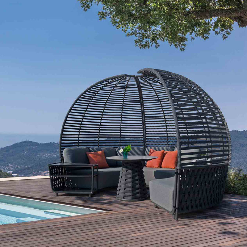 Complete Lawson Outdoor Rope Pavilion Lounge, featuring three arc-shaped sofas arranged in a semicircle, a side table at one end, a round dining table in the center, and a canopy frame surrounding the setup. All placed poolside with mountains in the background, highlighting sophisticated alfresco furniture for luxurious outdoor living.