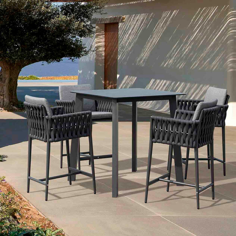 Four rope bar chairs paired with a matching square bar table, set outdoors on a sunny summer day, showcasing stylish alfresco furniture.