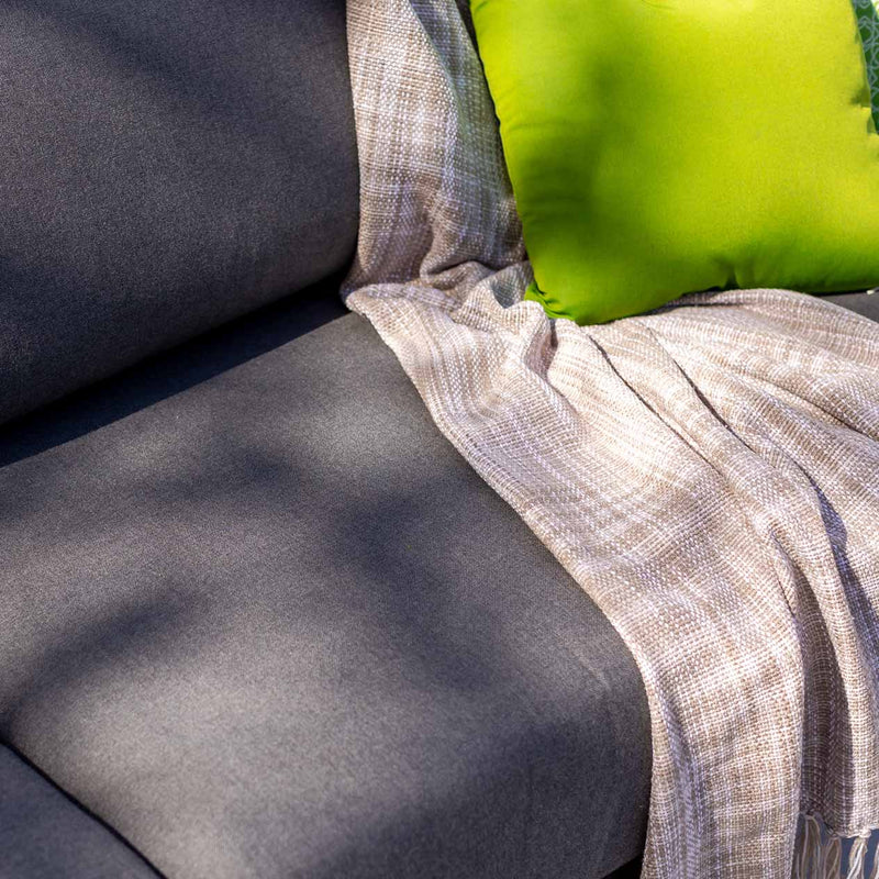 Outdoor furniture collection featuring aluminum outdoor lounge chair, two-seater, and three-seater sofas in charcoal or white, inspired by Hamptons style. Current image: A close up of a couch with a blanket on it.