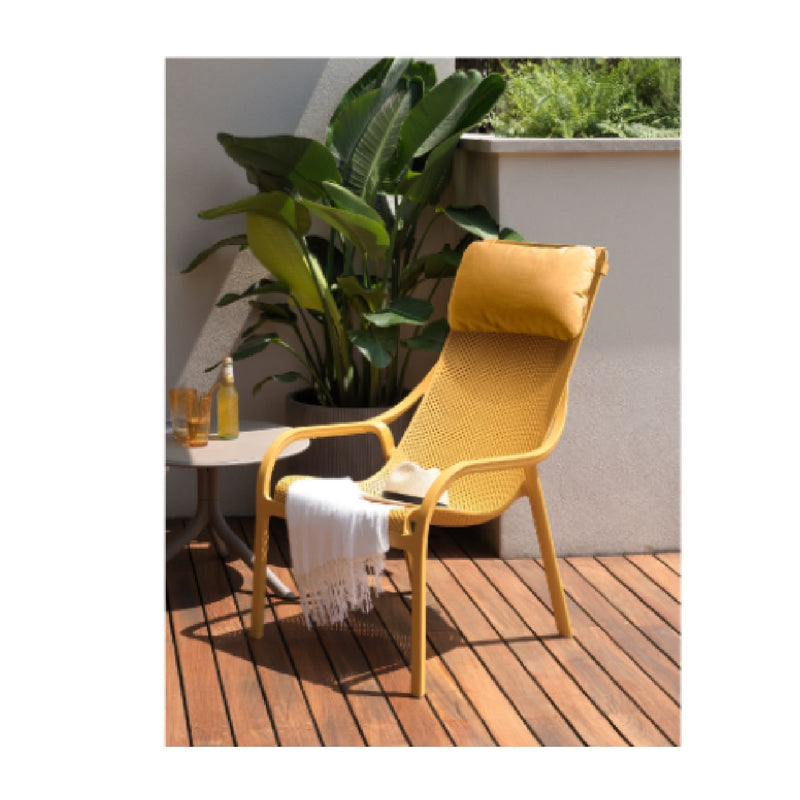 A yellow Nardi head cushion resting on a yellow Net Lounge chair on a wooden deck outdoors, with the sun shining in, creating a perfect spot for relaxation in outdoor living spaces, ideal for a balcony relax chair.