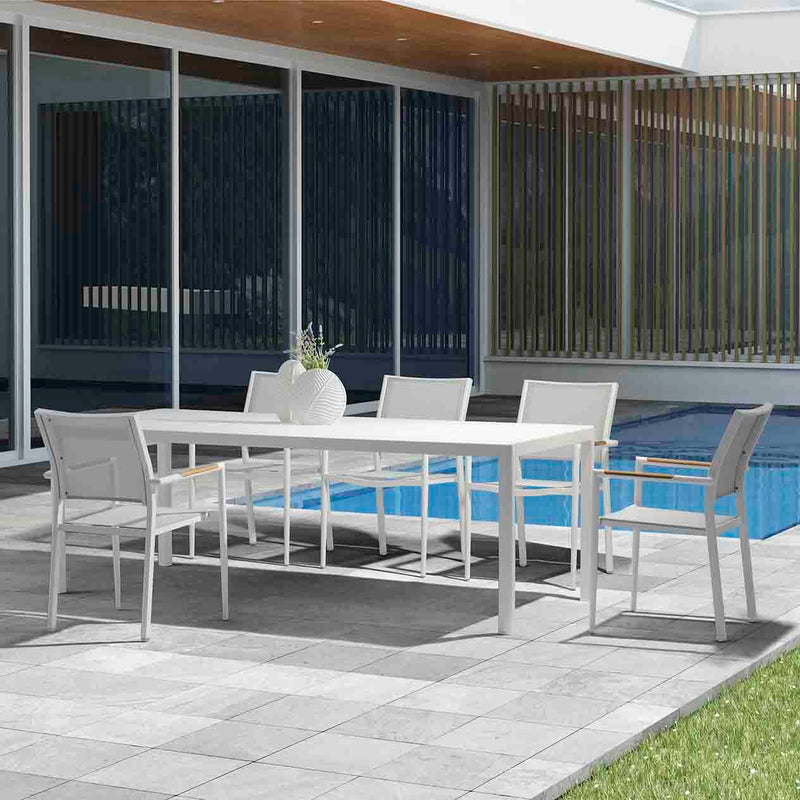 Five white Largo Outdoor Aluminum Dining Chairs surrounding a large dining table poolside in an outdoor area, highlighting sleek aluminium patio chairs perfect for alfresco dining.