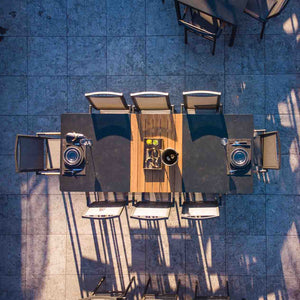 Eight black Largo Outdoor Aluminum Dining Chairs surrounding a large dining table in an outdoor area, highlighting sleek aluminium patio chairs perfect for alfresco dining.
