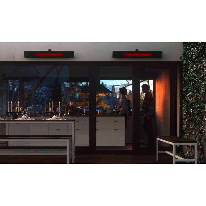 Two Heatscope Outdoor Pure+ 3000W heaters mounted above an outdoor eating area, offering warmth while a couple stands in the kitchen, enhancing the outdoor living experience.
